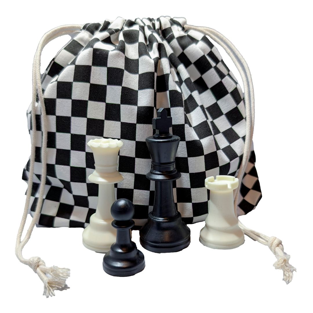 Skakternet brikpose placeret bagved fire forskellige skakbrikker i plastik