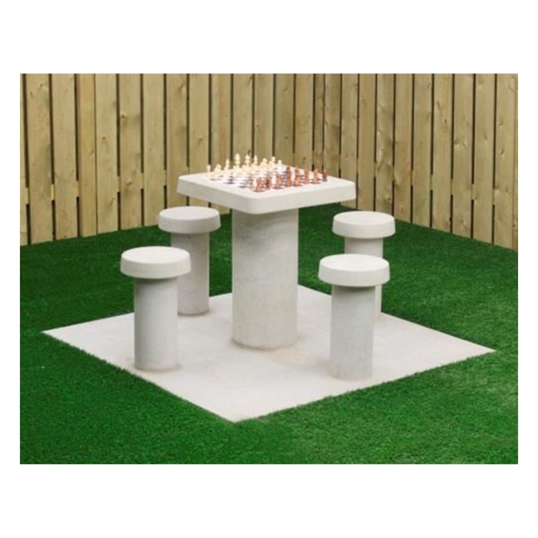 Skakbord i lyst beton med plads til fire personer og skakbrikker placeret på toppen klar til at spille et skakparti