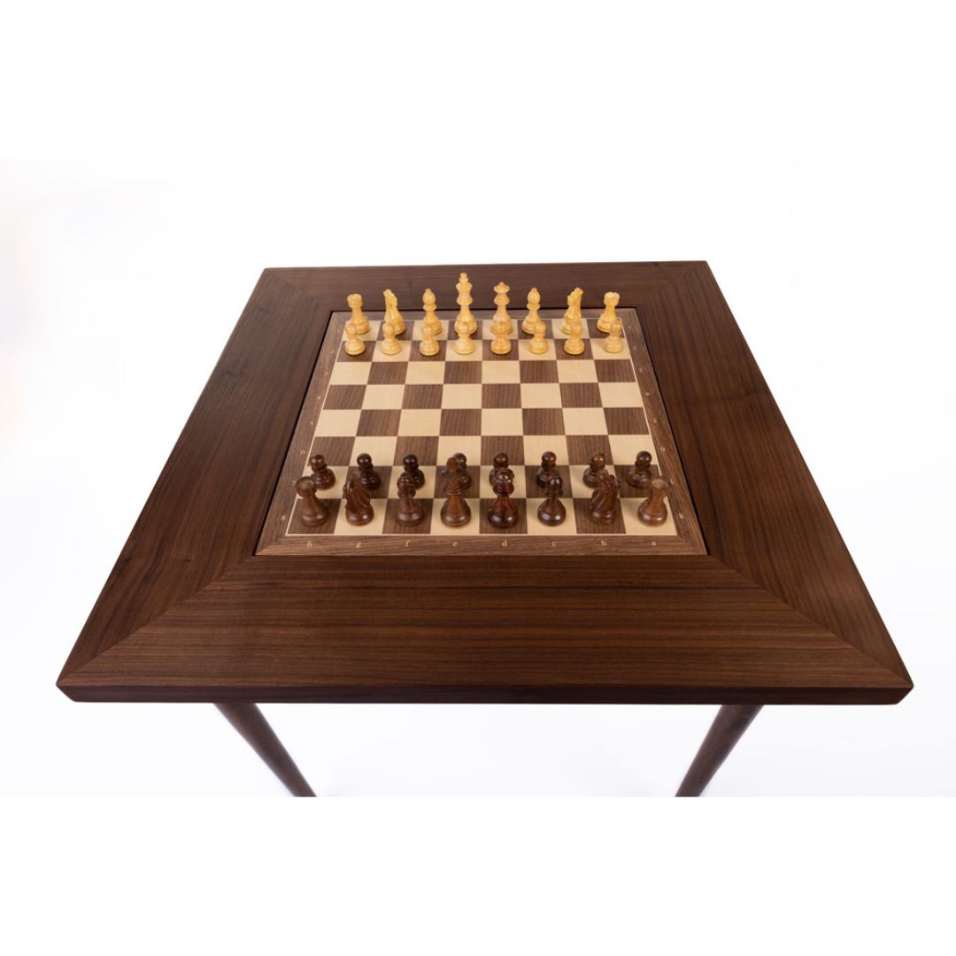 Skakbræt og skakbord i valnød set ovenfra med brikker på i skak opstilling lige inden det første træk spilles