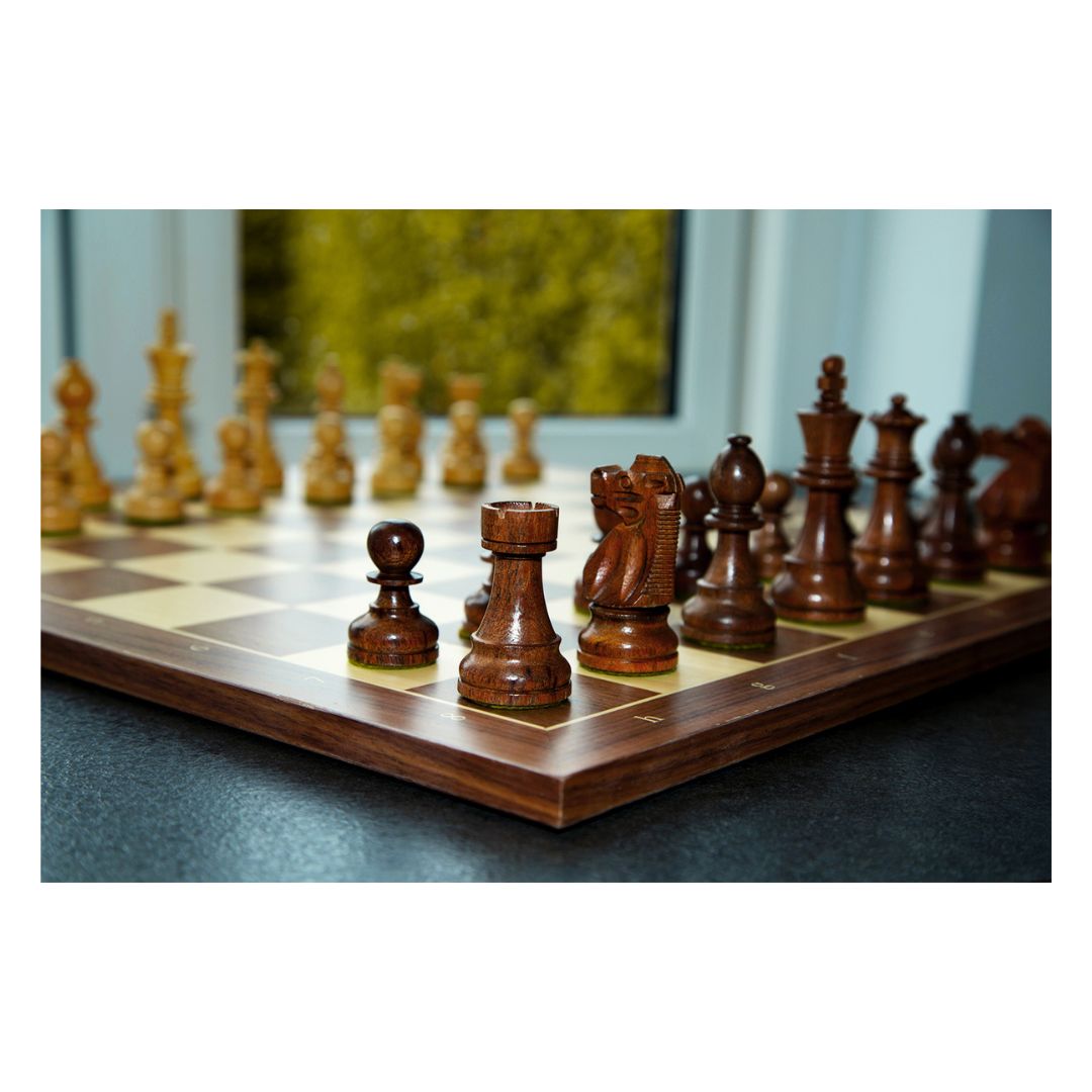 Den mørke skakbrik tårnet i fokus med de andre skakbrikker tilhørende et håndlavet skakspil fra Indien