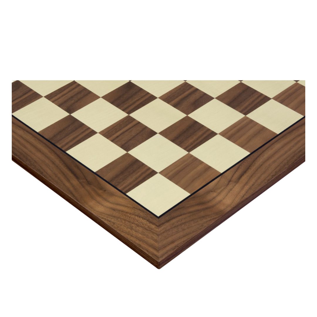 Hjørnet af et flot skakbræt i træ med fokus på de blanke felter i valnød og træramme uden notation