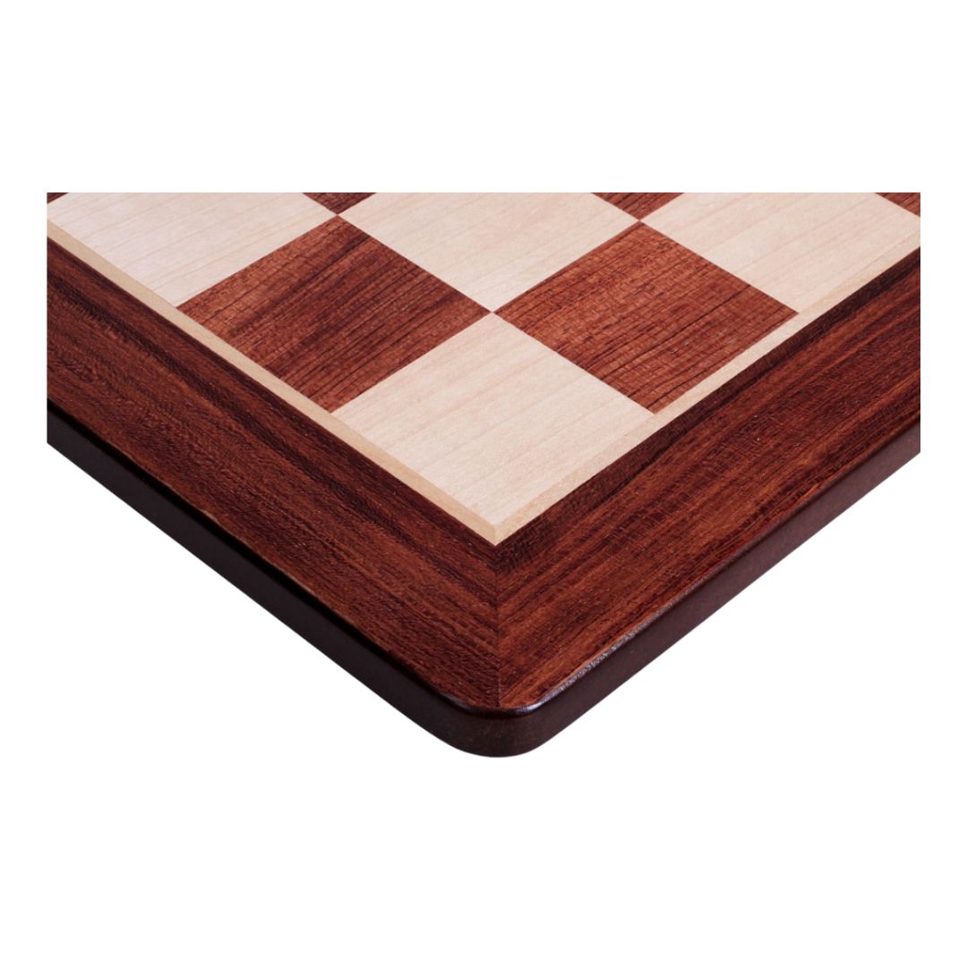 Fokus på hjørnet af skakbræt i padauk og ahorn med runde hjørner der er samlet flot og lagt en flot finish ved samlingerne