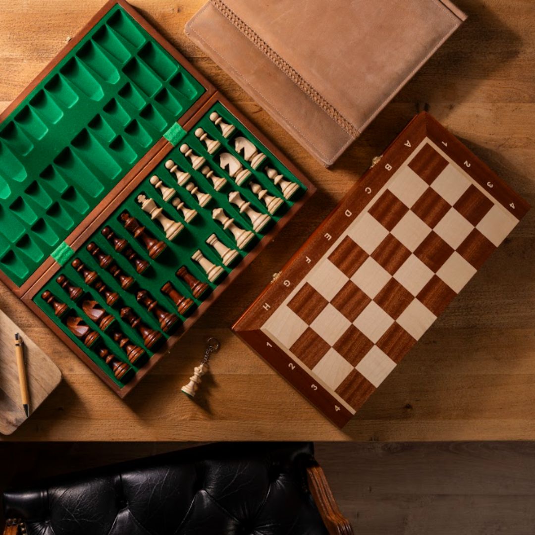 Sammenklappelige skakspil i træ med skakbrikker liggende i indsatsbakken, som holder skakbrikkerne sikkert opbevaret